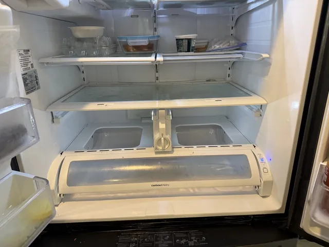 Open Samsung French-door refrigerator during a diagnosis, shelves and lower compartment in view